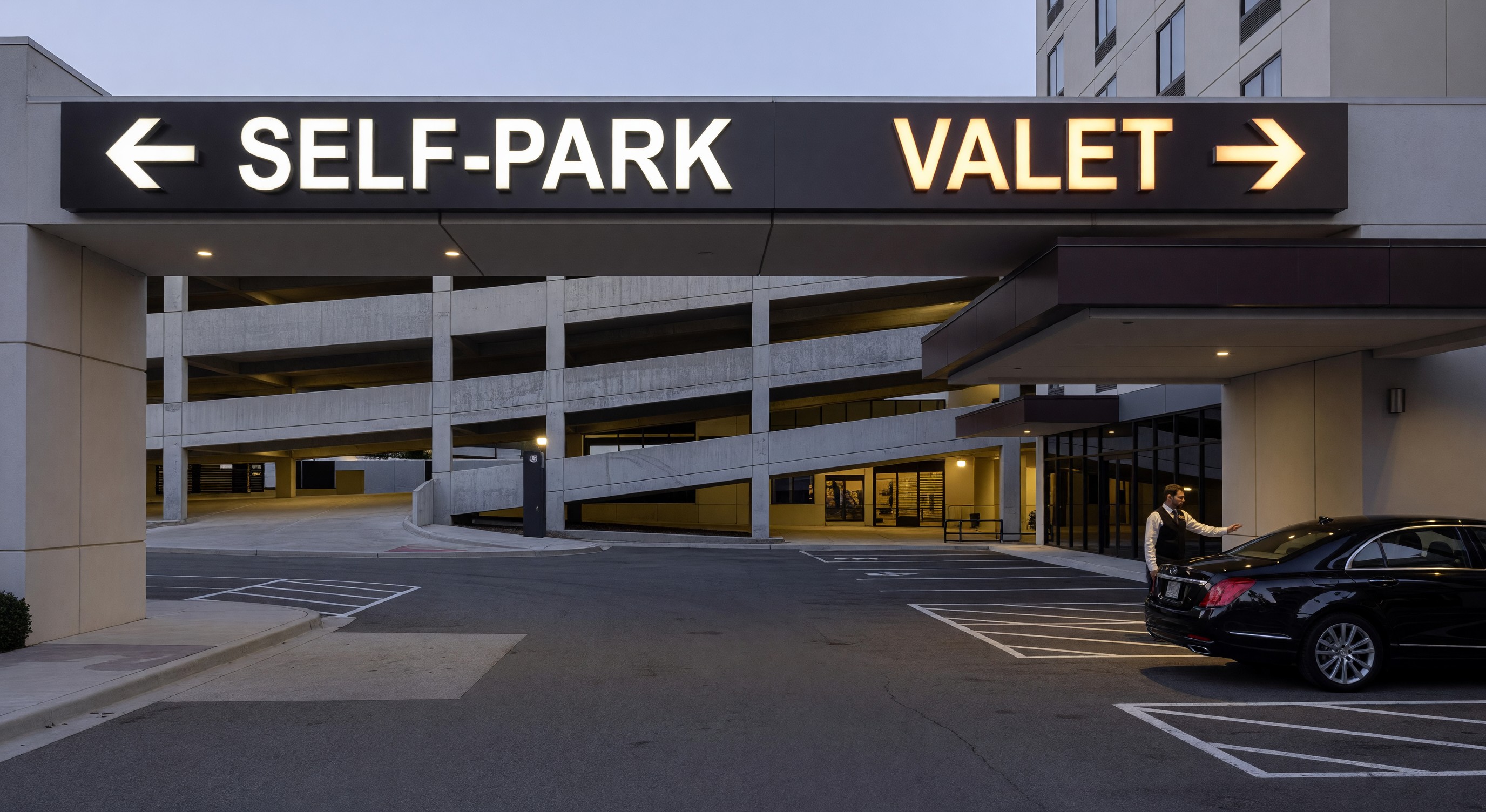 Hotel parking entrance with illuminated wayfinding signage directing guests to self-park and valet areas