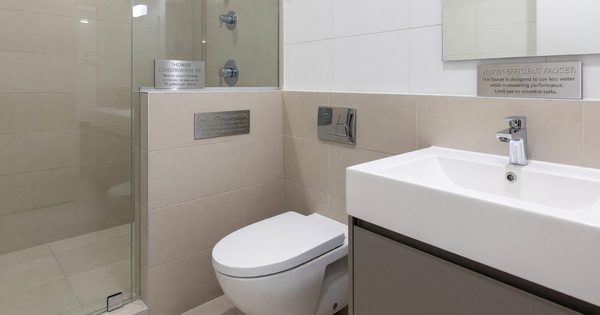 Hotel bathroom with water-efficient fixtures and conservation signage